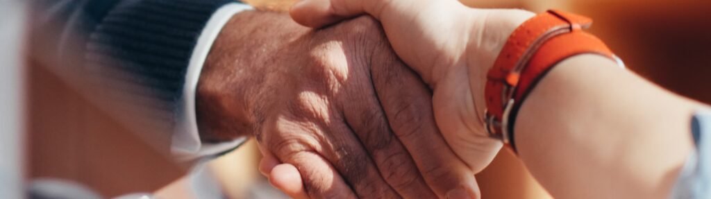 Poignée de main entre une conseillère immobilière et un client, symbole d'un accord conclu