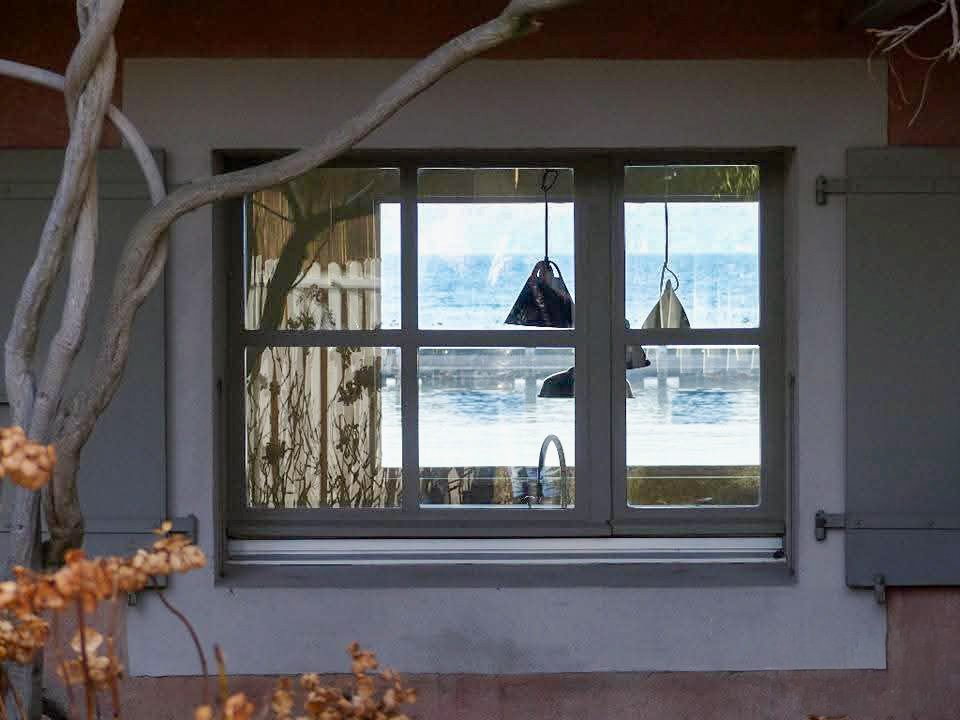 Vue sur le lac depuis une fenêtre à volets, photo personnelle (non libre de droit)